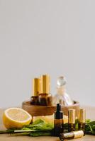 Essential oil in bottles with lemon and mint fragrance lying on a wooden surface photo