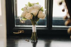 The bride's wedding bouquet of fresh pink flowers and wedding rings. Wedding Details photo