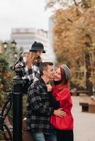 A stylish family of three strolls through the autumn city posing for a photographer . Dad, mom and daughter in the autumn city photo