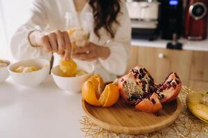 de cerca de el manos de un niña quien hace un desintoxicación cóctel de Fruta en el cocina. dieta para peso pérdida foto