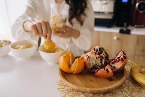 de cerca de el manos de un niña quien hace un desintoxicación cóctel de Fruta en el cocina. dieta para peso pérdida foto