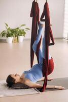 embarazada muchacha. un mujer lo hace yoga en un hamaca en el gimnasia. el concepto de un sano estilo de vida, maternidad foto