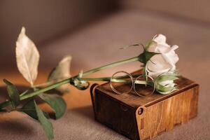 Designer wedding rings lying on the surface with a rose. Two wedding rings photo