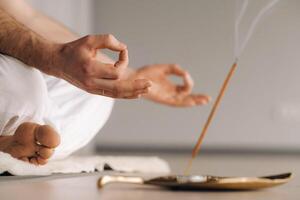 Close-up of a man in white sportswear doing yoga in a fitness room with a balgovon. the concept of a healthy lifestyle photo