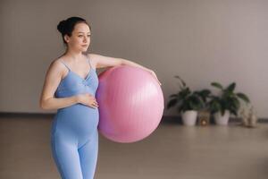 Pregnant woman during fitness classes with a fitball photo