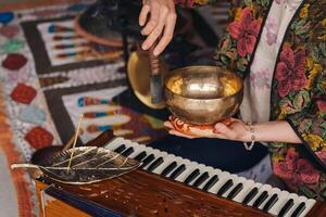 Tibetan singing bowl in the hands of a man during a tea ceremony photo