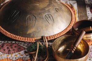 Tongue drum and Tibetan bowls lying on the carpet photo