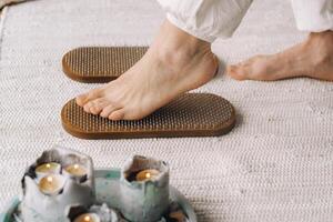 The man's feet are next to boards with nails. Yoga classes photo