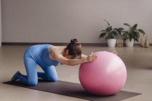 Pregnant woman during fitness classes with a fitball photo