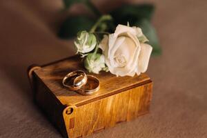 Designer wedding rings lying on the surface with a rose. Two wedding rings photo