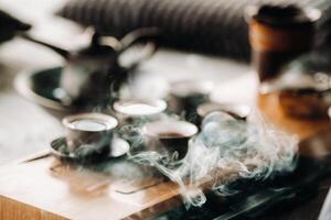 Cups with poured tea before the tea ceremony with incense photo