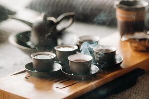 Cups with poured tea before the tea ceremony with incense photo