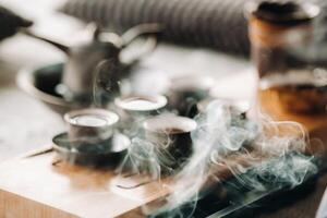 Cups with poured tea before the tea ceremony with incense photo