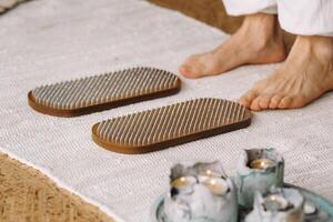 The man's feet are next to boards with nails. Yoga classes photo