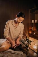 A masseuse gives a head massage to a woman at the spa. A professional masseur massages the head of a girl lying in a spa center photo