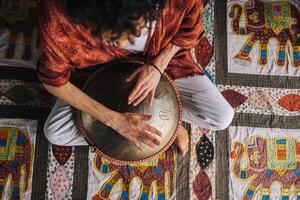 Close-up of a man's hand playing a modern musical instrument, the orion reed drum photo