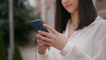 Business woman using smart phone outside workplace. video