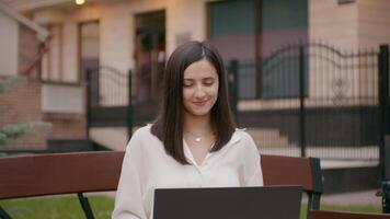 Woman remotely working having video call outside office.