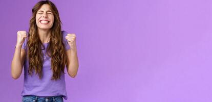 Yes I did it. Relieved happy triumphing joyful girl pump fists celebrating excellent achievement raise head up close eyes thank god winning first prize stand purple background happy photo