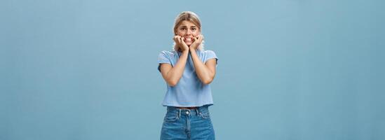 Attractive adult girl scared dad knows her secret standing over blue background frowning biting fingernails worrying and feeling anxious thinking about bad consequences insecure and nervous photo