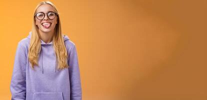 Funny charming female programmer having fun show tongue fool around coworkers during lunch break smiling broadly laughing in cute glasses purple hoodie, standing purple background photo