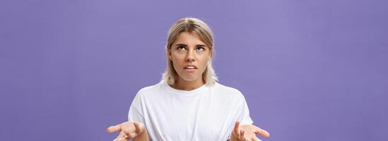 no yo tener No idea. retrato de irritado molesto guapo europeo mujer con justa pelo laminación ojos arriba con decepcionado expresión encogiéndose de hombros con manos elevado en despistado gesto foto