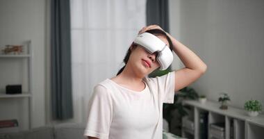 Footage selective focus shot, Happy young woman wear VR goggles standing is practicing yoga and stretching her neck at home with eyes closed, relaxing body and mind alone in the living room video