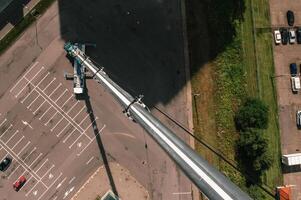 view from the height of the Car heavy crane that stands open in the Parking lot and ready to work. the highest truck crane is deployed on the site. the height of the boom is 80 meters photo