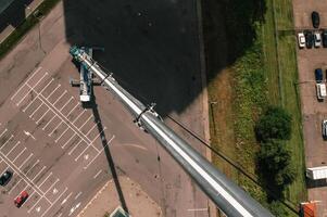 view from the height of the Car heavy crane that stands open in the Parking lot and ready to work. the highest truck crane is deployed on the site. the height of the boom is 80 meters photo