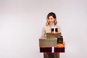 A girl in a skirt and jacket with a lot of gifts in her hands on a white background photo