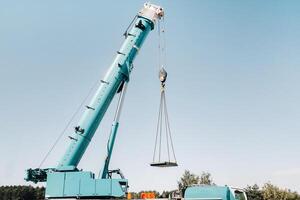 the stove is loaded onto a large blue car crane and prepared for operation . The largest truck crane for solving complex tasks. photo