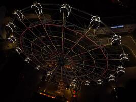 Beautiful sunset over the city with a lighted Ferris wheel. photo