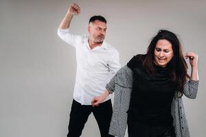 A man swings his hand at a battered woman standing on a gray background. Domestic violence photo