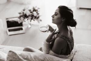 a relaxed girl at home drinks coffee and watches a movie.Domestic calm.The girl is sitting comfortably on the sofa and drinking coffee.black and white photo