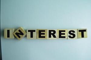 Concept of The wooden Cubes with the word Interest on wooden background. photo