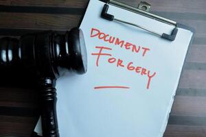 Concept of Document Forgery write on paperwork isolated on wooden background. photo