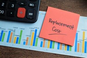 Concept of Replacement Cost write on sticky notes isolated on Wooden Table. photo