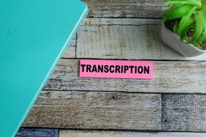 Concept of Transcription write on sticky notes isolated on Wooden Table. photo