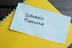 Concept of Scenario Planning write on sticky notes isolated on Wooden Table. photo