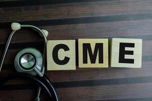 Concept of The wooden Cubes with the word CME on wooden background. photo