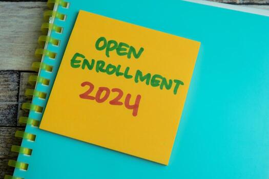 Concept of Open Enrollment 2024 write on sticky notes isolated on Wooden Table. photo