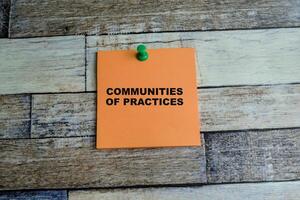 Concept of Communities of Practices write on sticky notes isolated on Wooden Table. photo