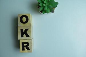 Concept of The wooden Cubes with the word OKR on wooden background. photo
