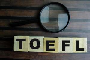 Concept of The wooden Cubes with the word TOEFL on wooden background. photo