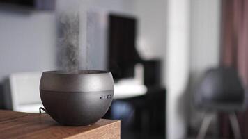 Grey aroma oil diffuser on light table at home, air freshener. High quality 4k footage video