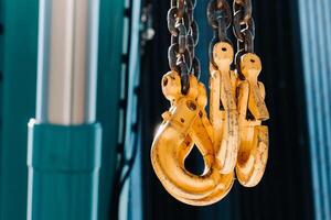 The hooks of the mobile crane near the glass of high buildings.Lots of hooks hanging from chains suspended from a crane photo