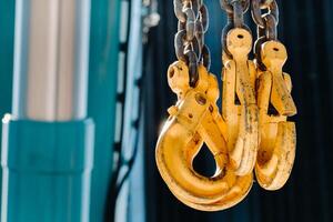 Yellow crane hooks hanging on a chain. Construction concept photo