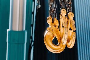 The hooks of the mobile crane near the glass of high buildings.Lots of hooks hanging from chains suspended from a crane photo