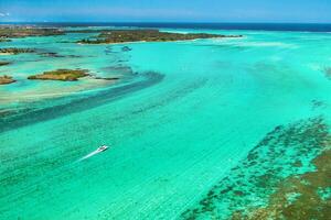 Aerial picture of the east coast of Mauritius Island. Beautiful lagoon of Mauritius Island shot from above. Boat sailing in turquoise lagoon photo