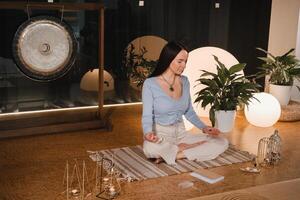 A young woman sitting in the Lotus position before the Game was playing and holding game cubes in her hand photo